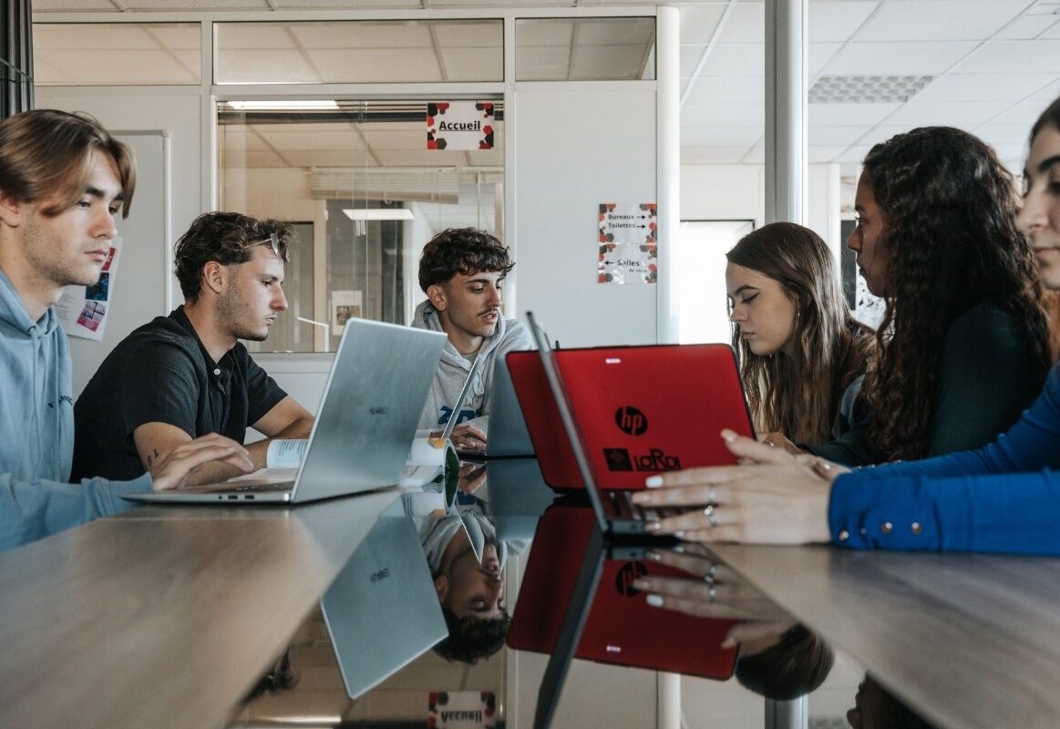 2 Étudiants ISTEG en salle de classe travaillant sur leurs laptops